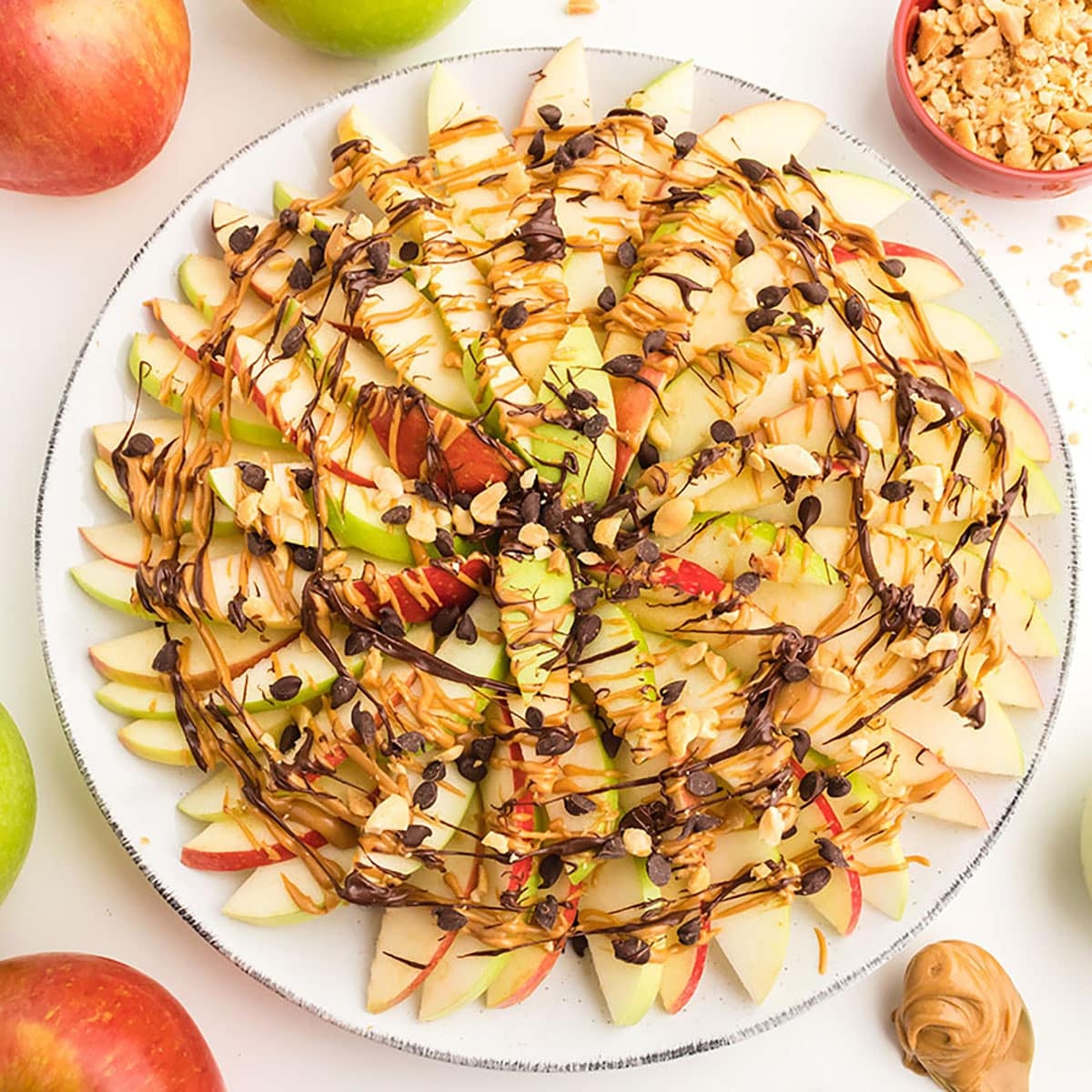 overhead shot of apple nachos drizzled with peanut butter and chocolate.
