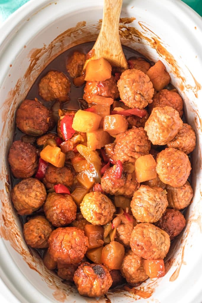 overhead shot of hawaiian meatballs in a white slow cooker.