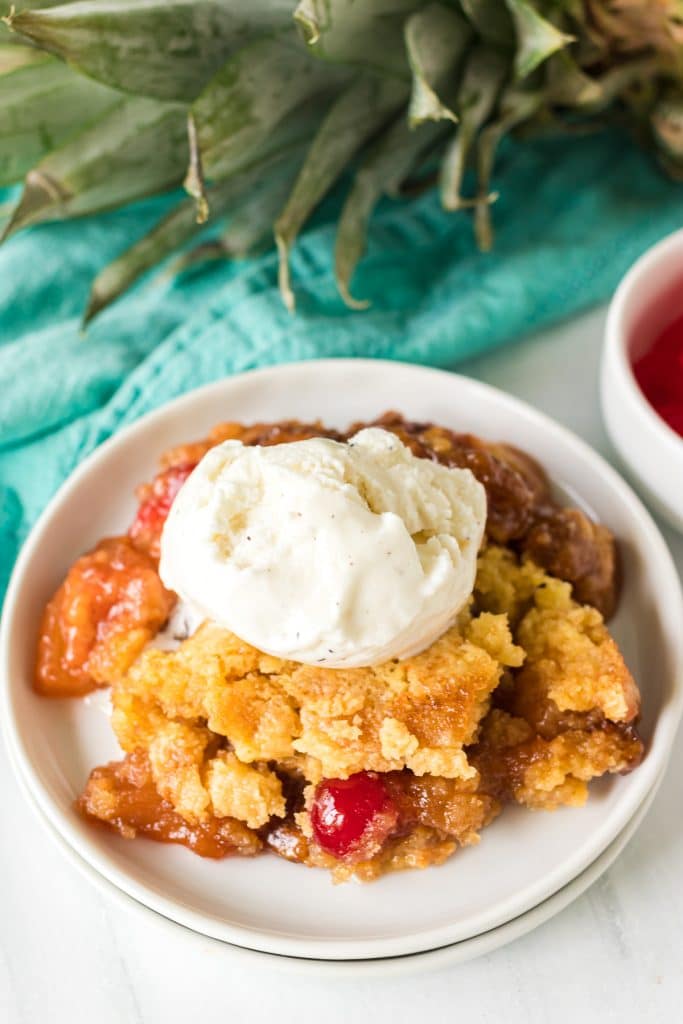 pineapple dump cake topped with vanilla ice cream.