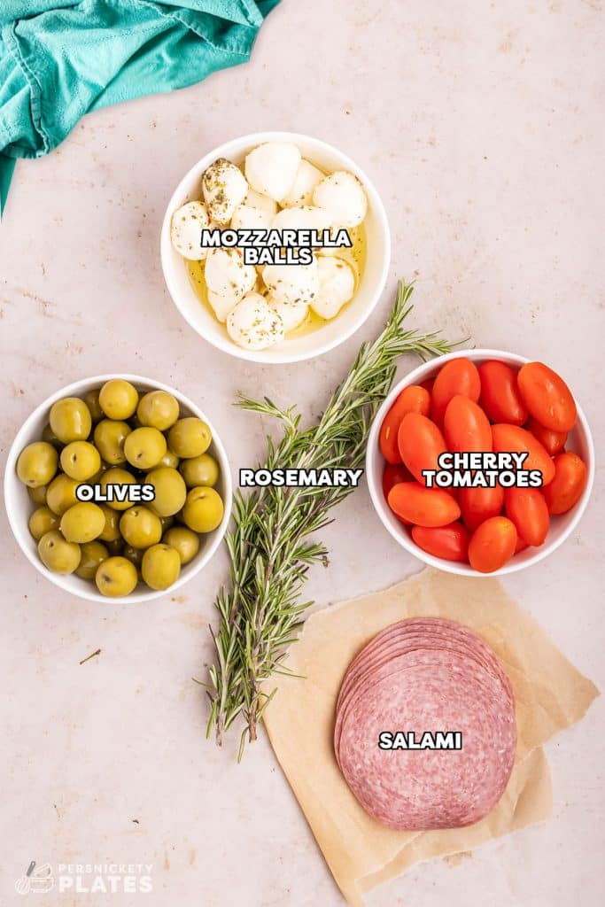 overhead shot of labeled ingredients laid out to make an antipasto platter.