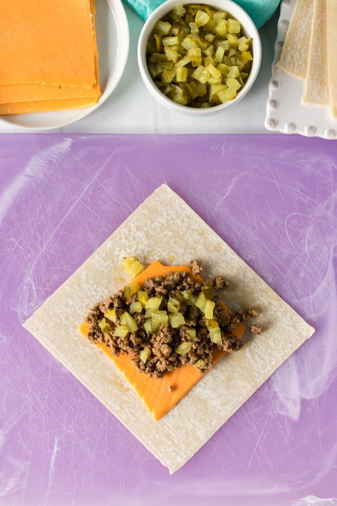 overhead shot of an unwrapped cheeseburger egg roll being assembled.