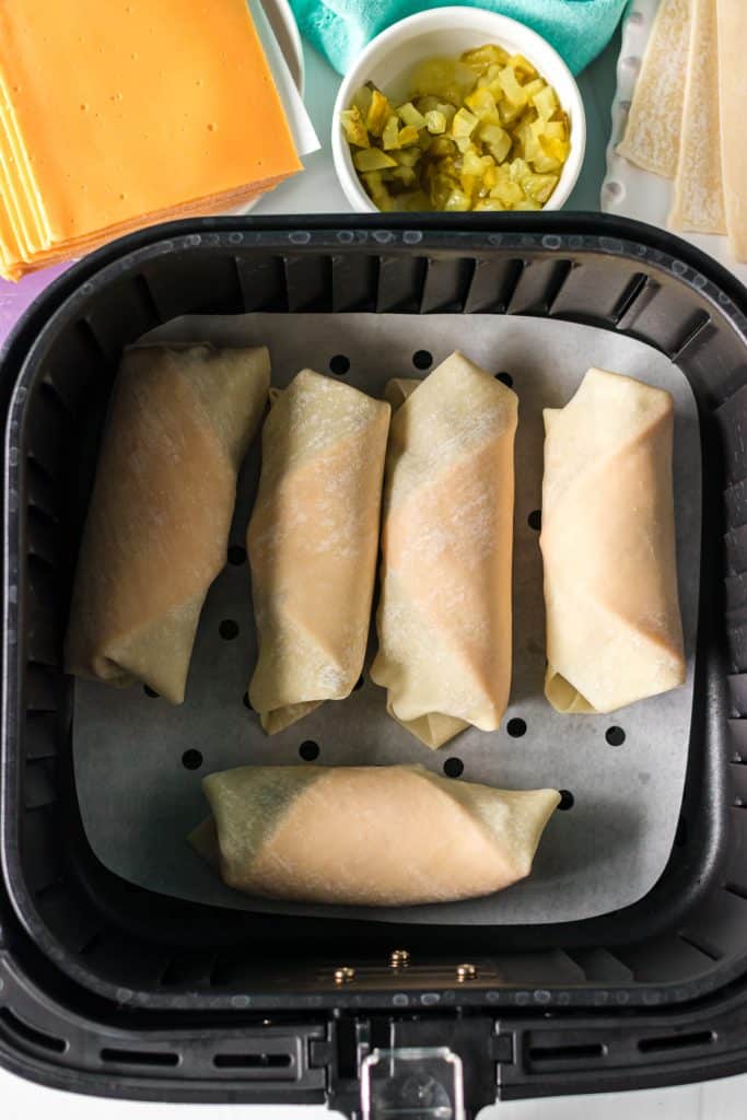 overhead shot of egg rolls in an air fryer basket.