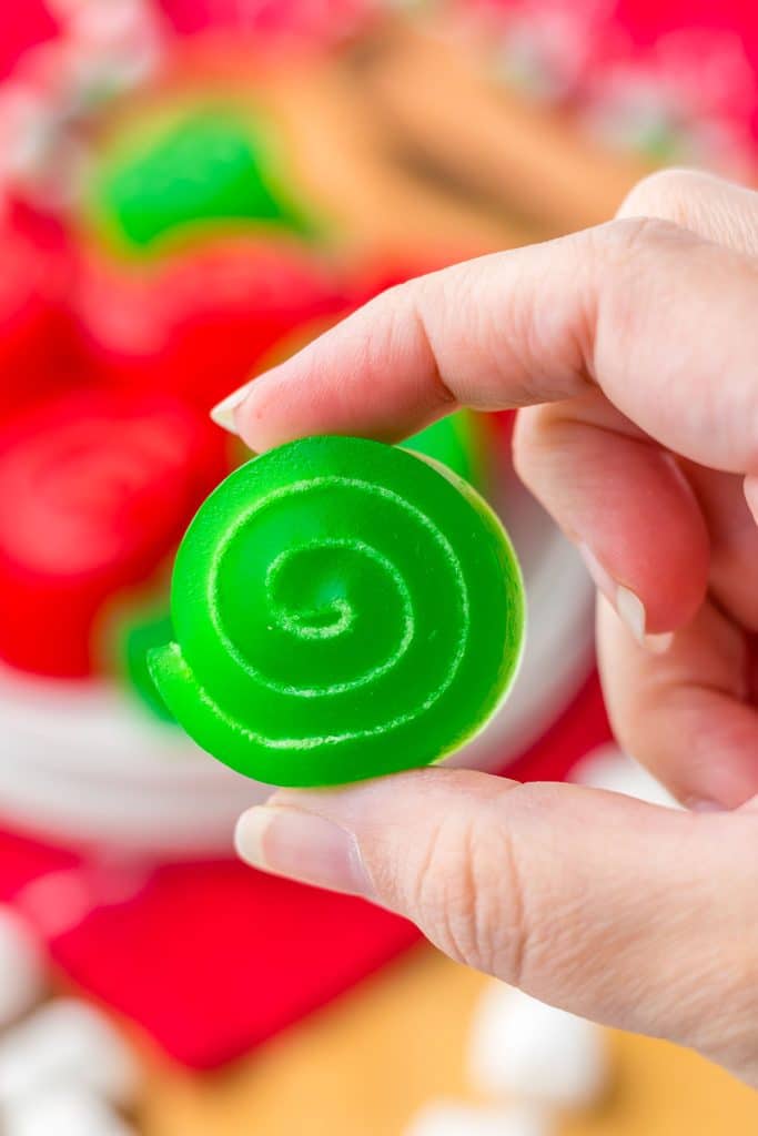 hand holding a green jello rollup.