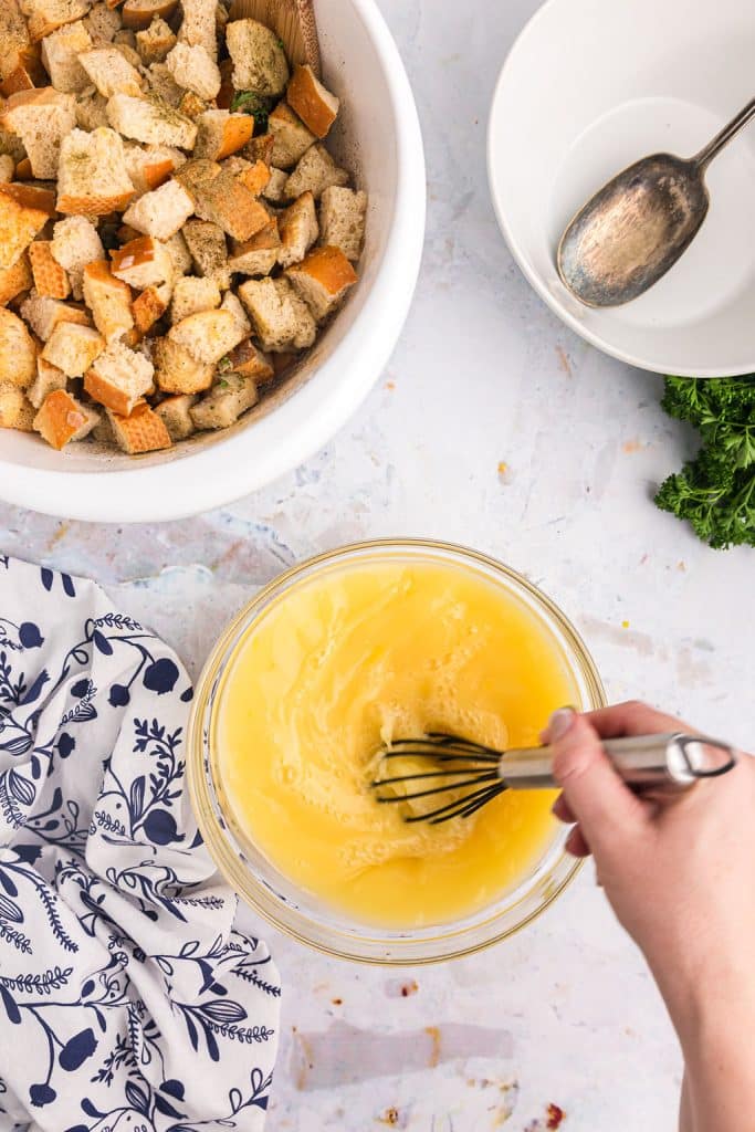 hand whisking eggs and broth to make stuffing.