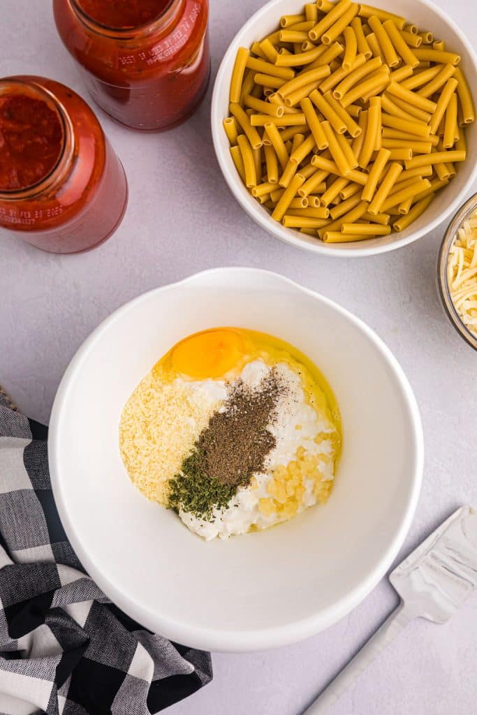overhead shot of egg & seasoning in a white mixing bowl.