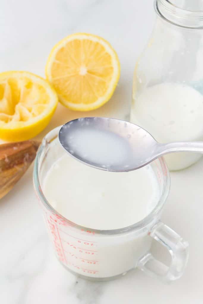 spoon lifting buttermilk from a measuring cup.