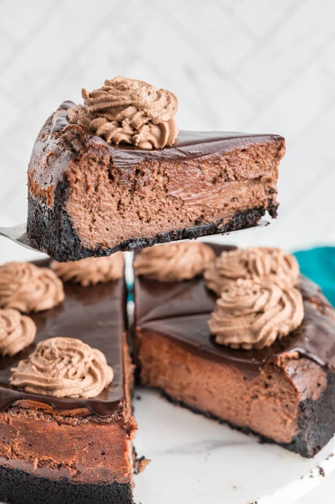 a slice of chocolate cheesecake being lifted from a plate.