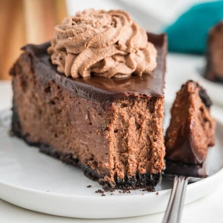 slice of triple chocolate cheesecake with a bite missing.