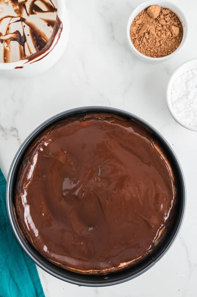 shiny melted chocolate poured over a cheesecake.