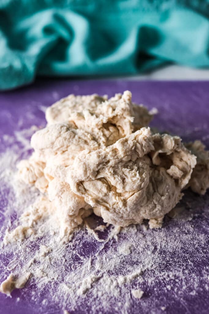 bagel dough on a purple cutting board.