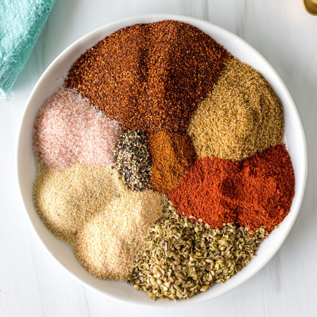 seasonings on a plate to make a homemade chili seasoning blend.