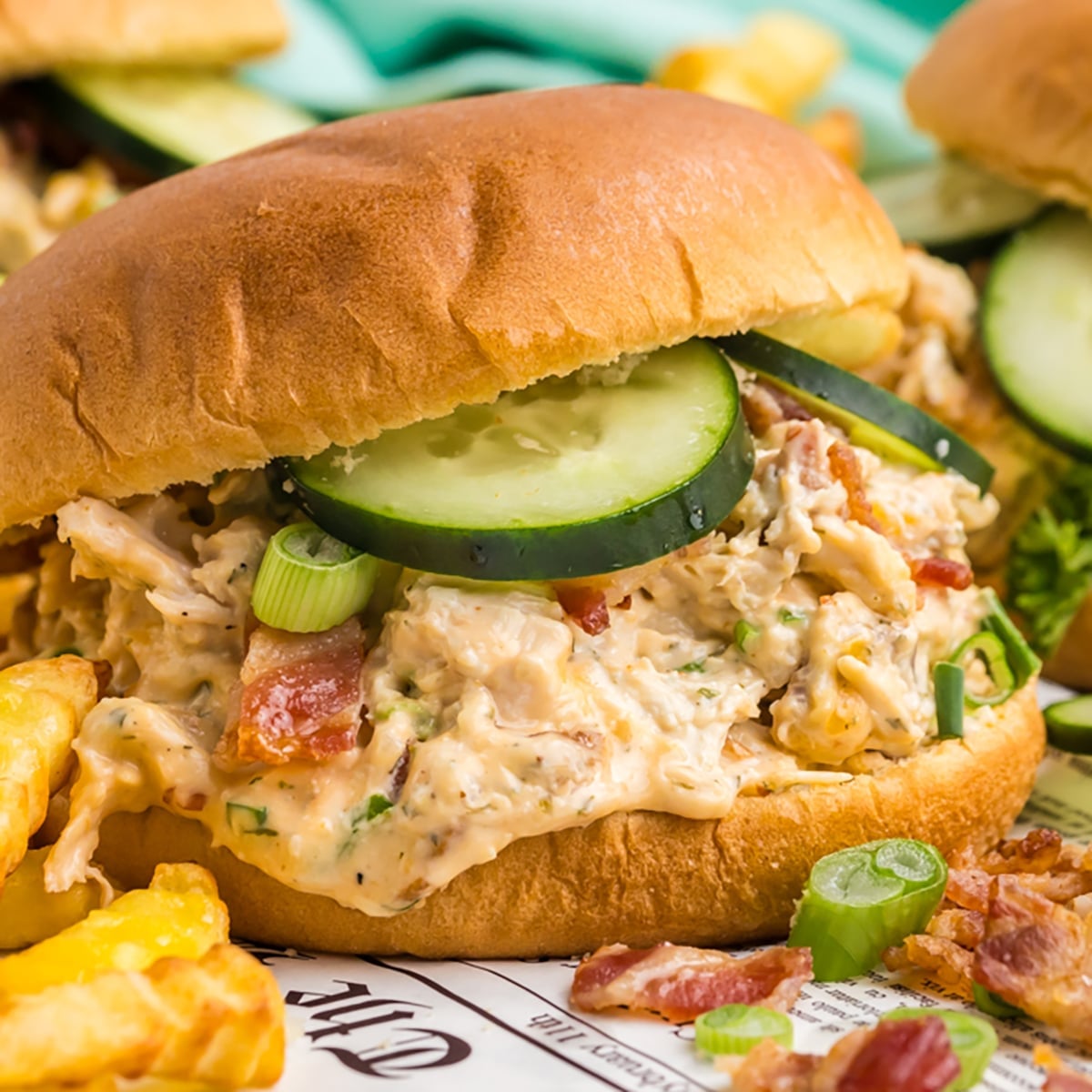 bacon ranch chicken sandwich topped with cucumbers.