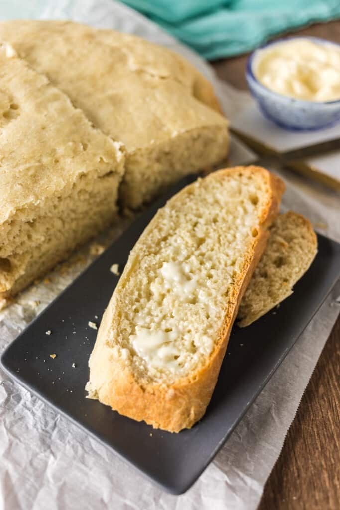 buttered slice of bread on a plate.