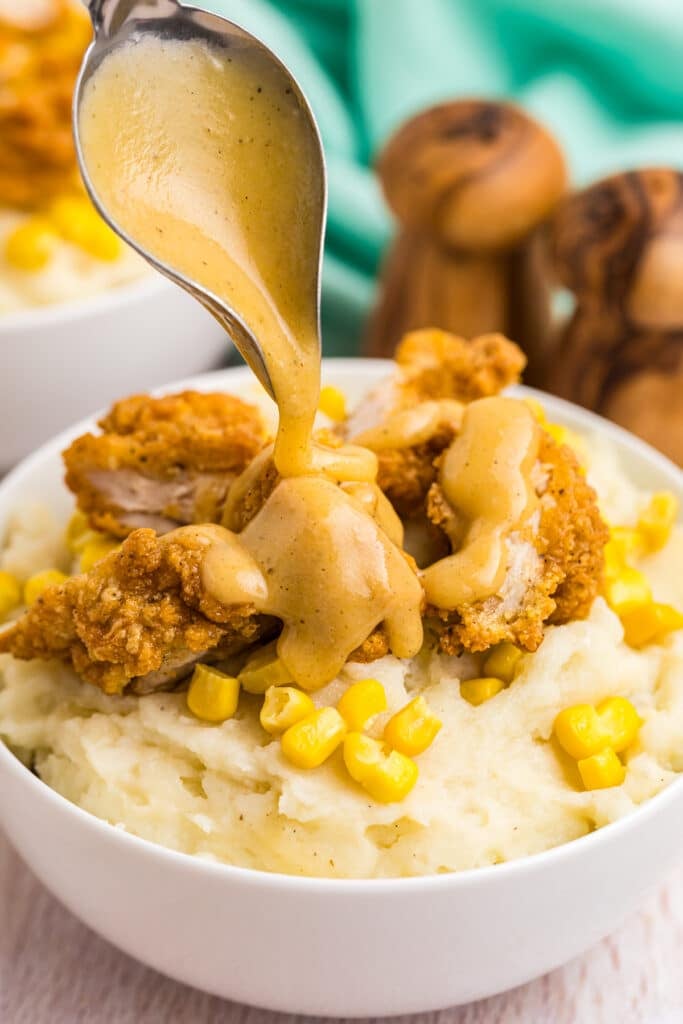 gravy drizzling over a loaded mashed potato bowl.