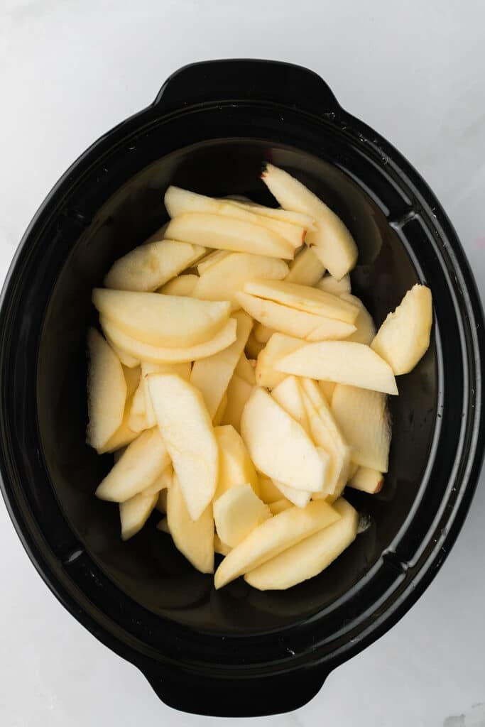 overhead shot of sliced apples in a crock pot.