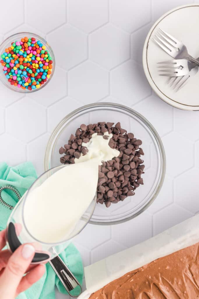 heavy cream pouring into a bowl of chocolate chips.