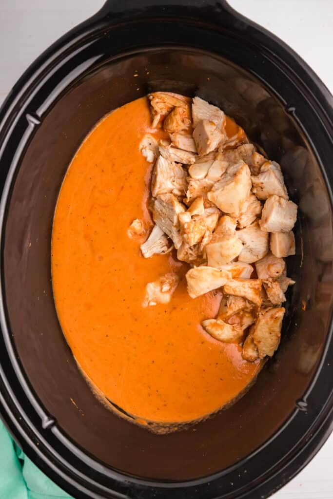 diced chicken in creamy sauce in a crockpot.