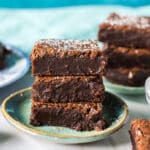 stack of 3 fudgy brownies on a plate.
