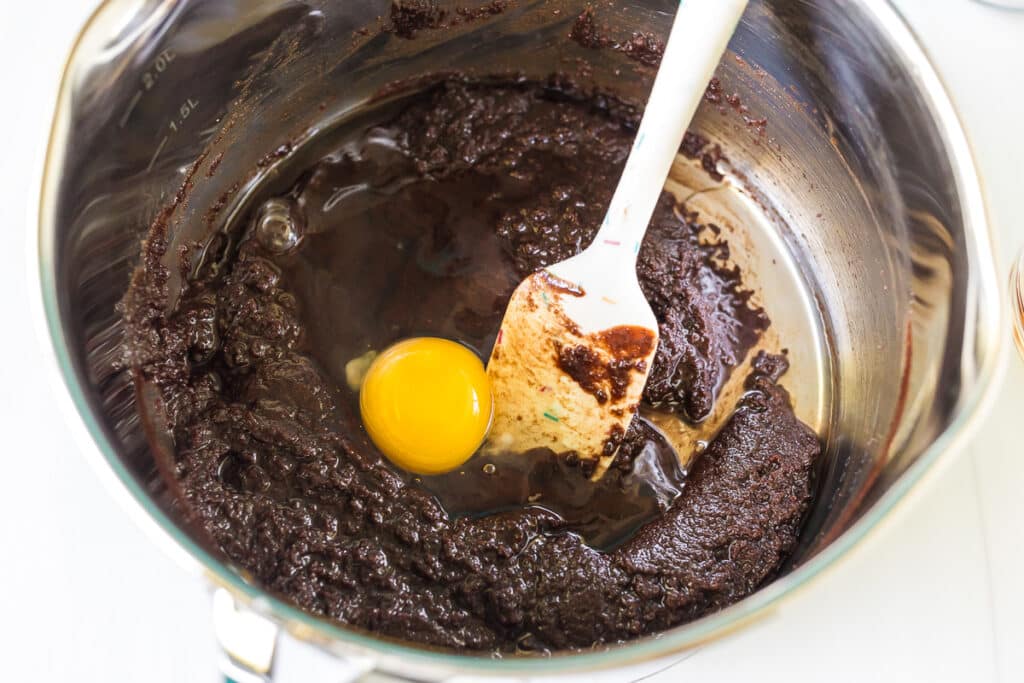 an egg in a saucepan with brownie batter.