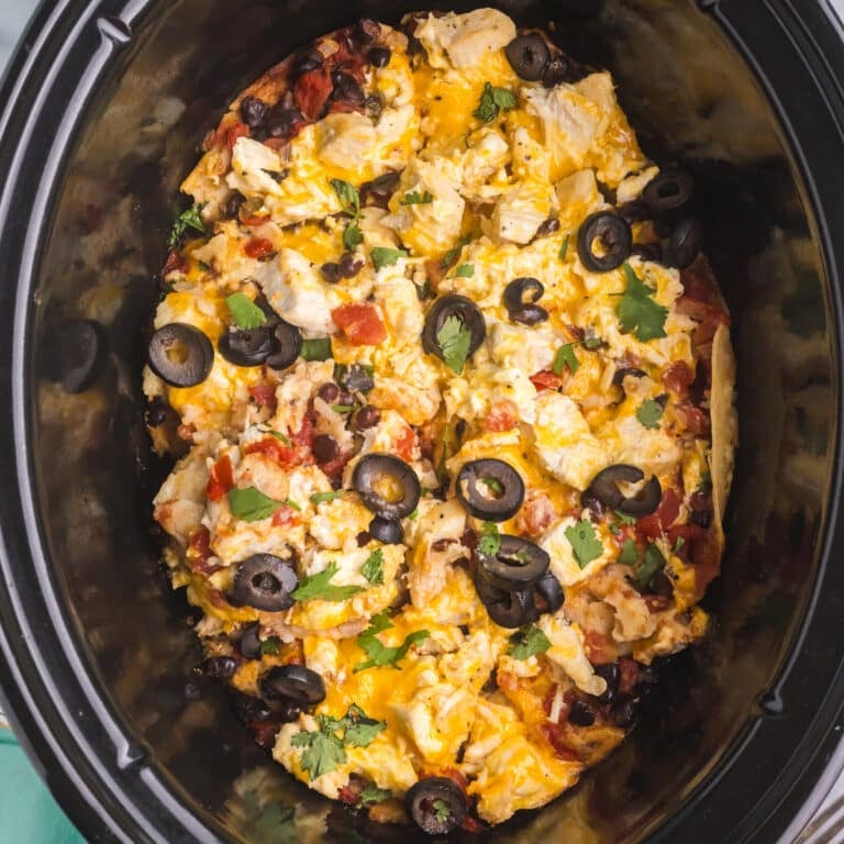 overhead shot of chicken enchilada casserole in a slow cooker.