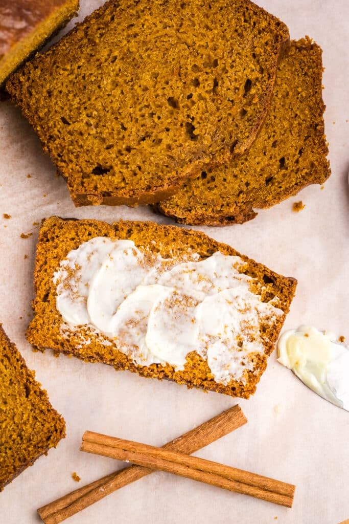 overhead shot of a slice of buttered pumpkin bread.