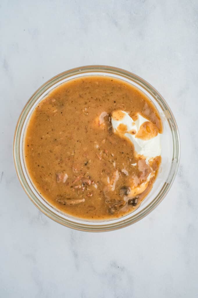 gravy in a bowl with sour cream mixing in.