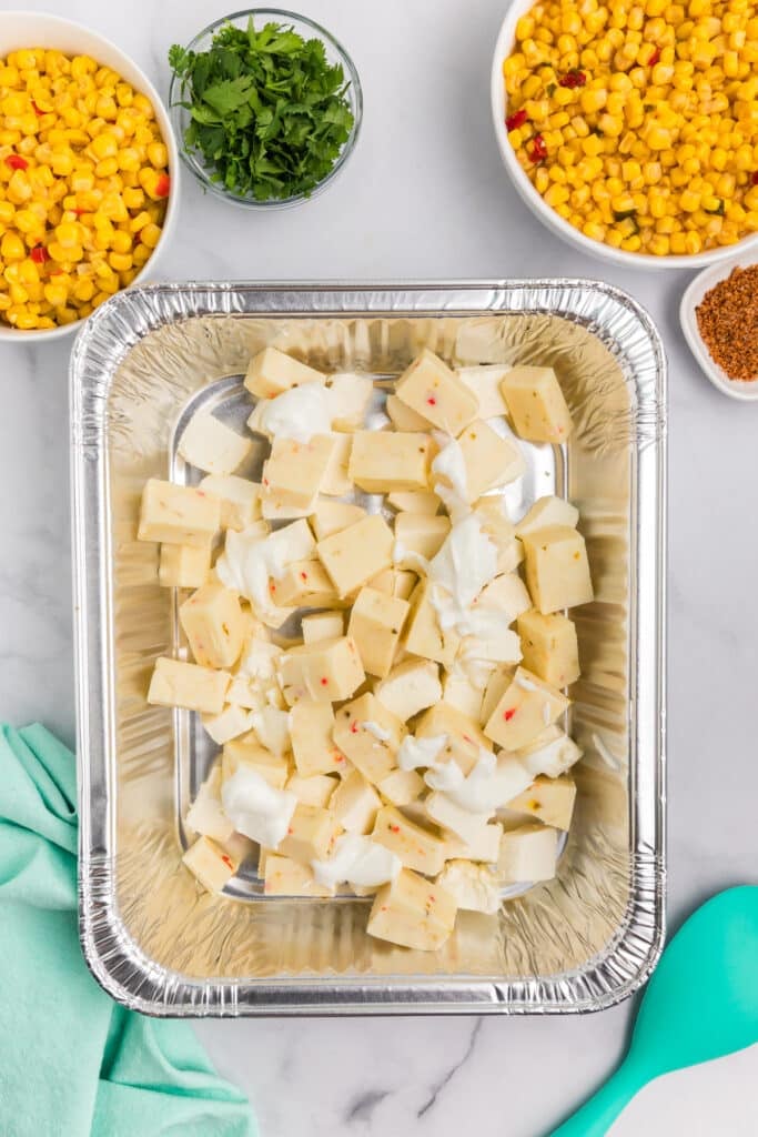 cubed cheeses in a aluminum pan.