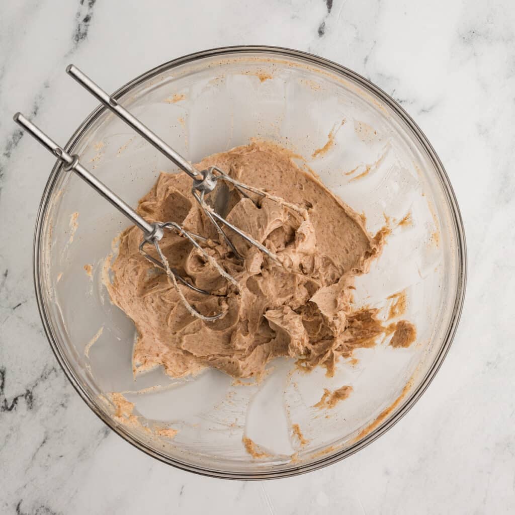 two mixer beaters in a bowl of cinnamon honey butter.