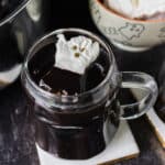 mug of black hot cocoa with a ghost marshmallow.