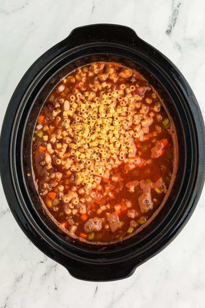 overhead shot of ditalini pasta in a crockpot soup.
