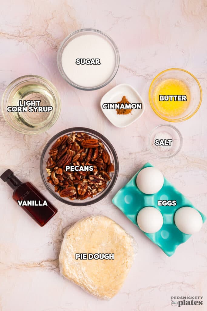 overhead shot of labeled ingredients laid out to make a traditional pecan pie.