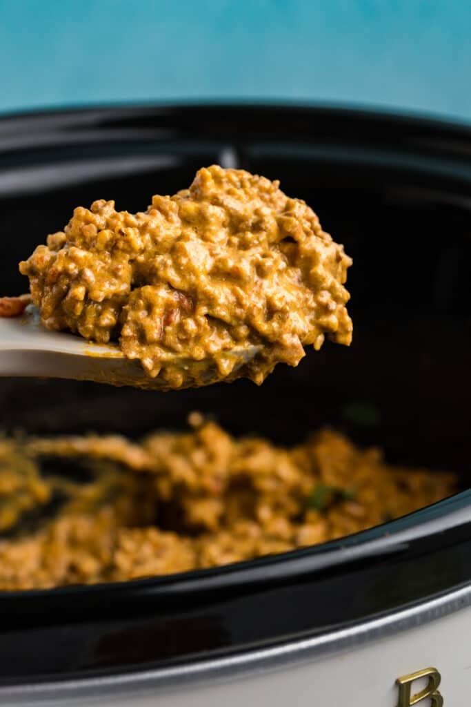 scoop of rotel taco meat scooping from a slow cooker.