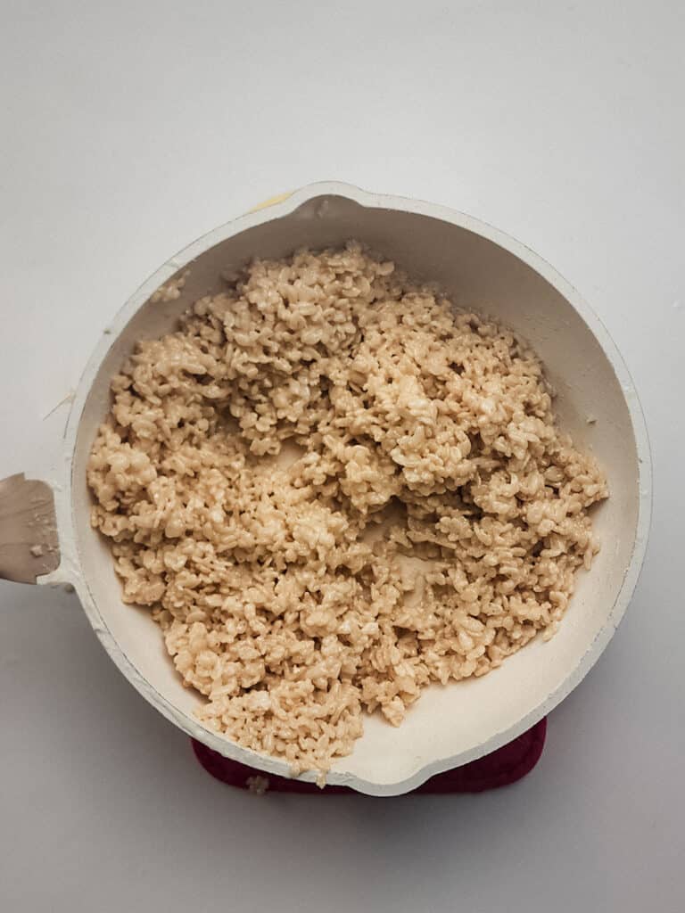 A saucepan filled with a mixed batch of Rice Krispies treats.