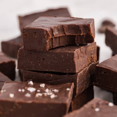 Stack of dark chocolate fudge with a bite taken out of the top piece.