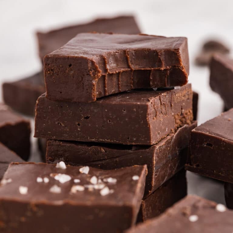 Stack of dark chocolate fudge with a bite taken out of the top piece.