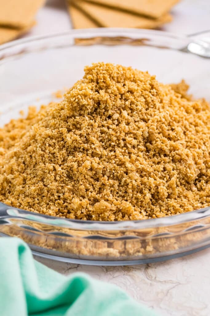 Pile of graham cracker crumbs in a glass dish.