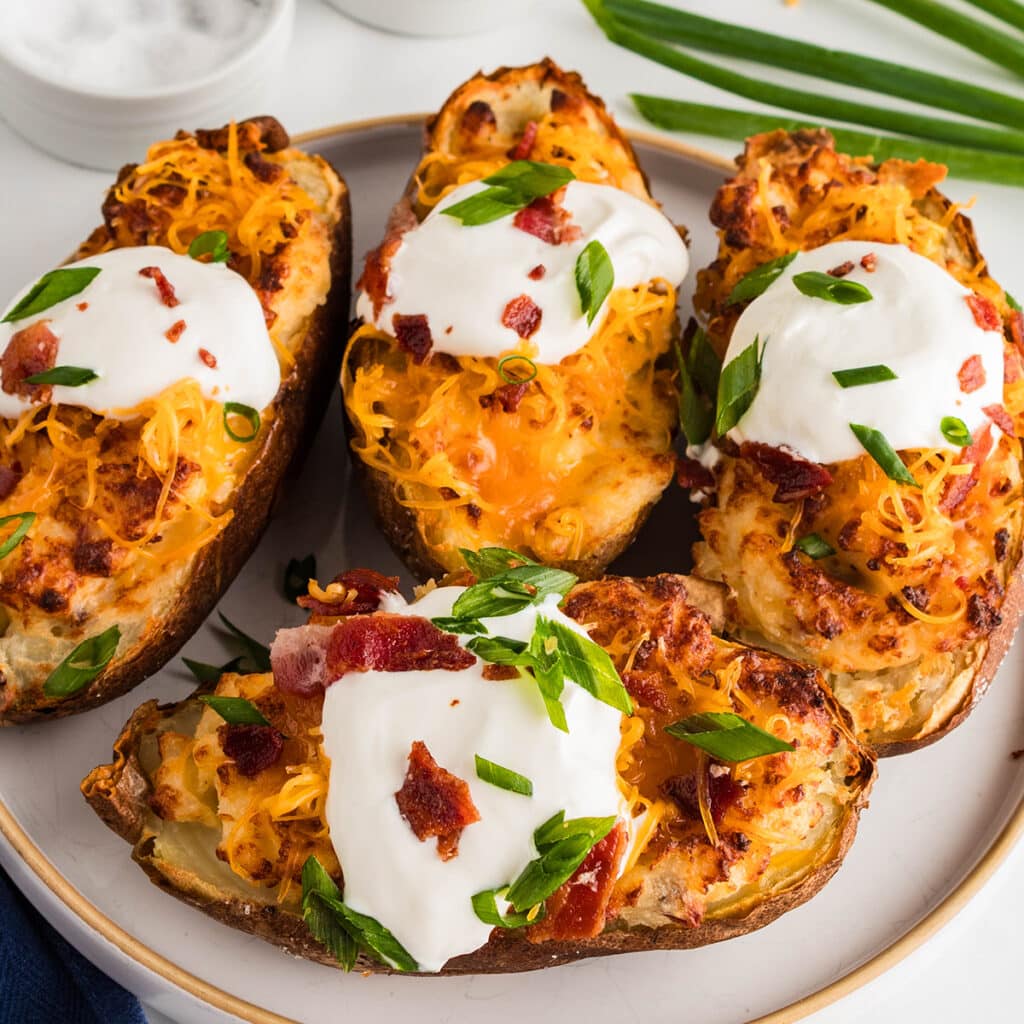 plate of twice baked potatoes topped with sour cream and chives.