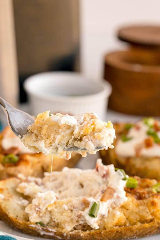 fork lifting a bite of twice baked potato.
