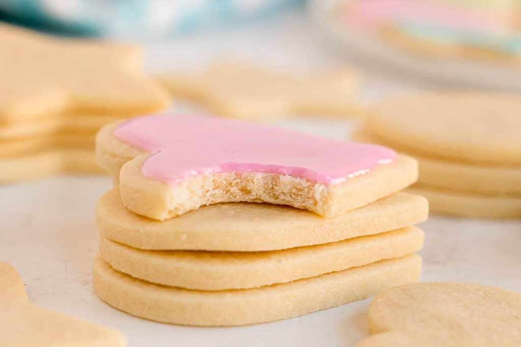 A bitten pink-iced heart cookie stacked on others.
