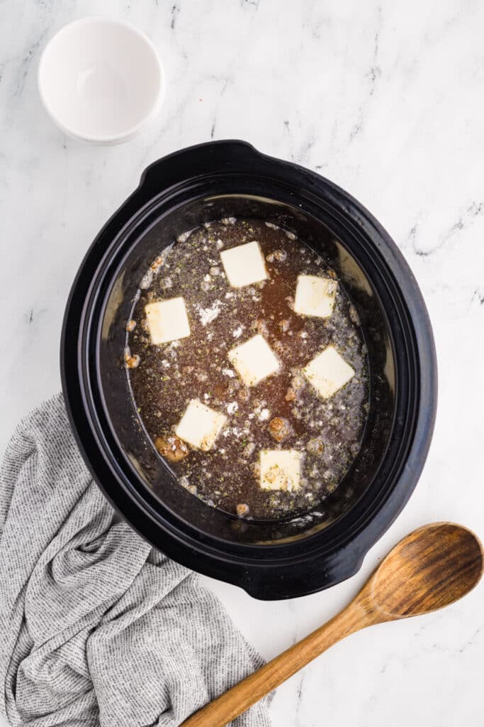 cubed butter in broth in a crockpot.