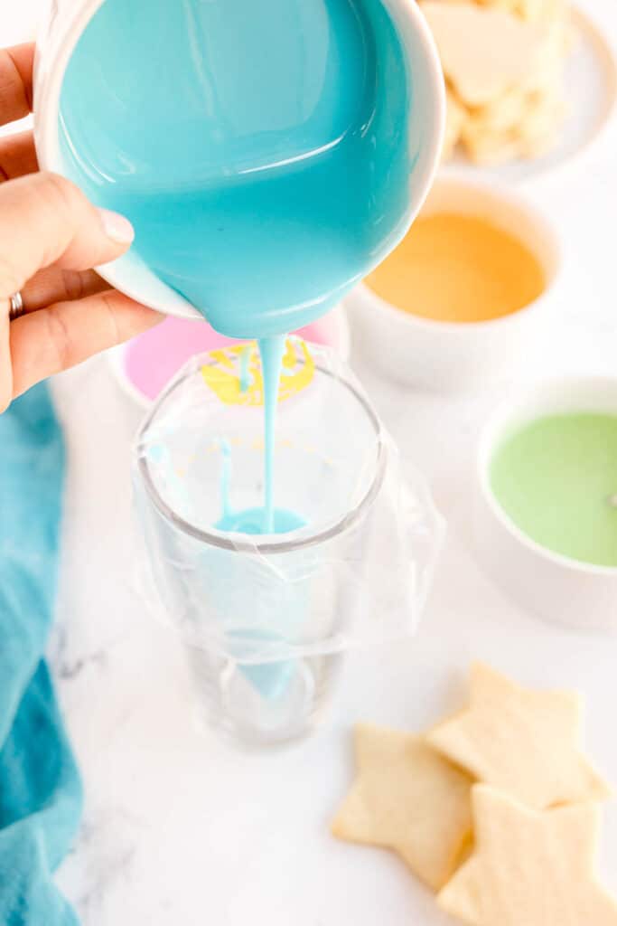 Pouring blue icing into a piping bag.