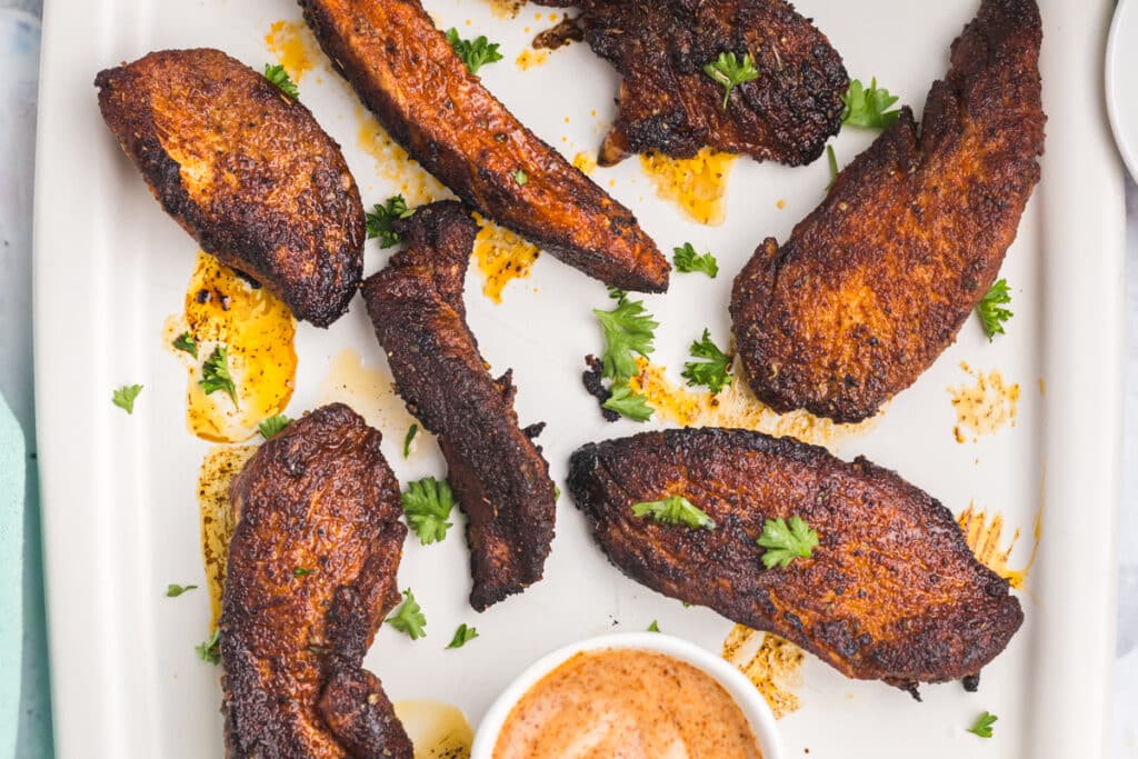 overhead shot of blackened tenders on a platter with dipping sauce.