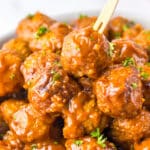 Close-up of saucy Coca-Cola meatballs with a skewer.