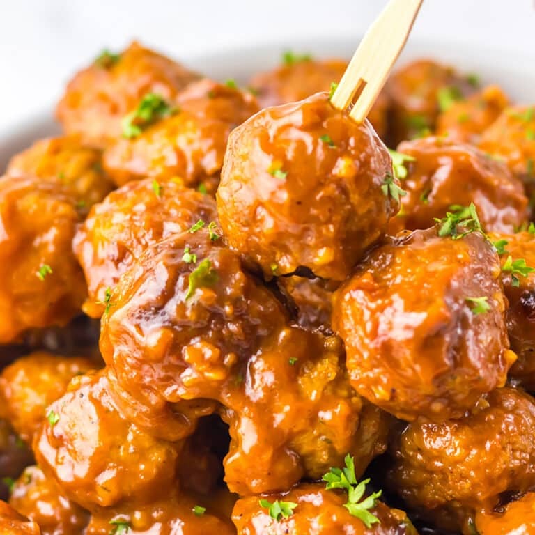 Close-up of saucy Coca-Cola meatballs with a skewer.