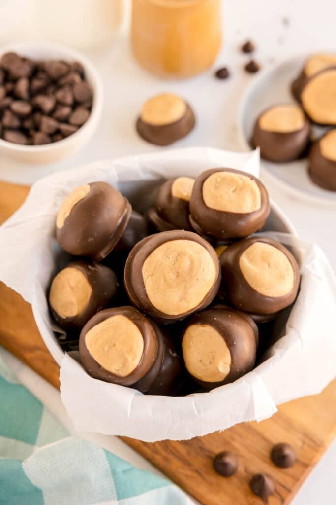 A bowl of peanut butter buckeye balls on a wood board.