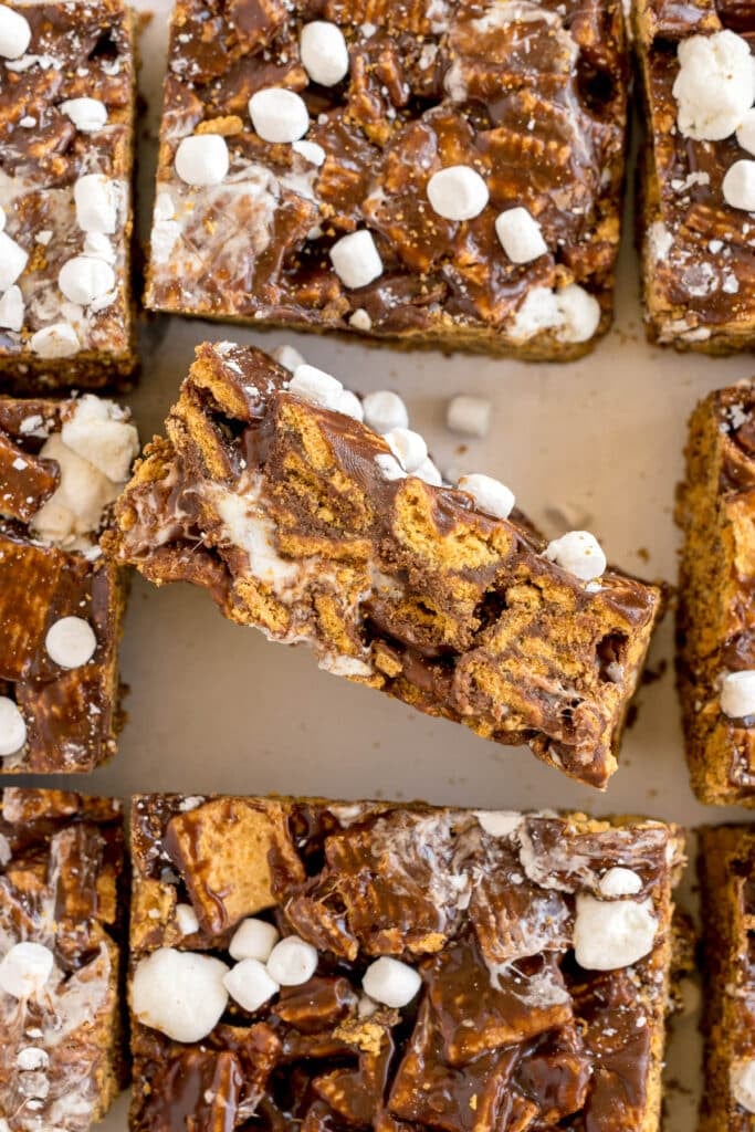 Top-down view of s’mores bars with one bar turned sideways showing melted filling.