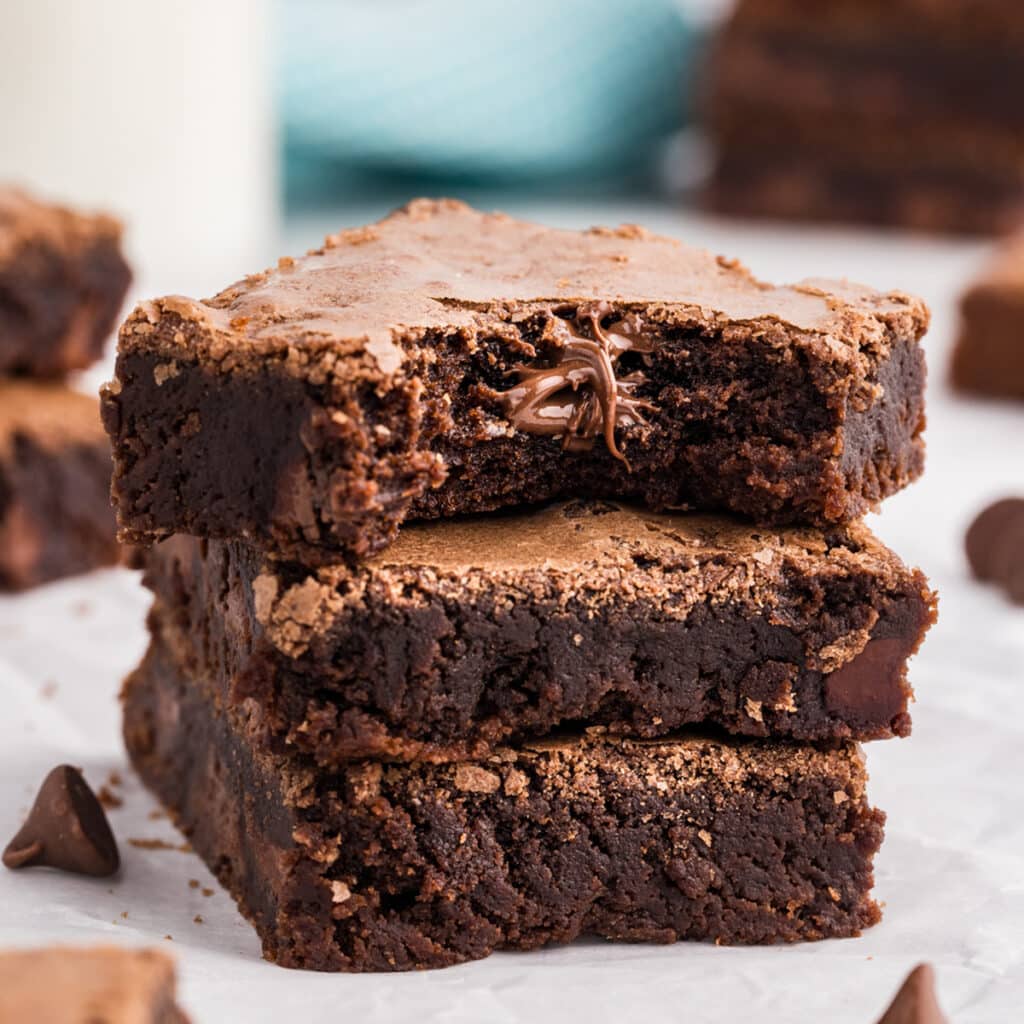 Stack of three brownies with melted chocolate center visible in top piece.
