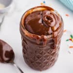 A jar filled with thick homemade hot fudge, dripping down the sides.