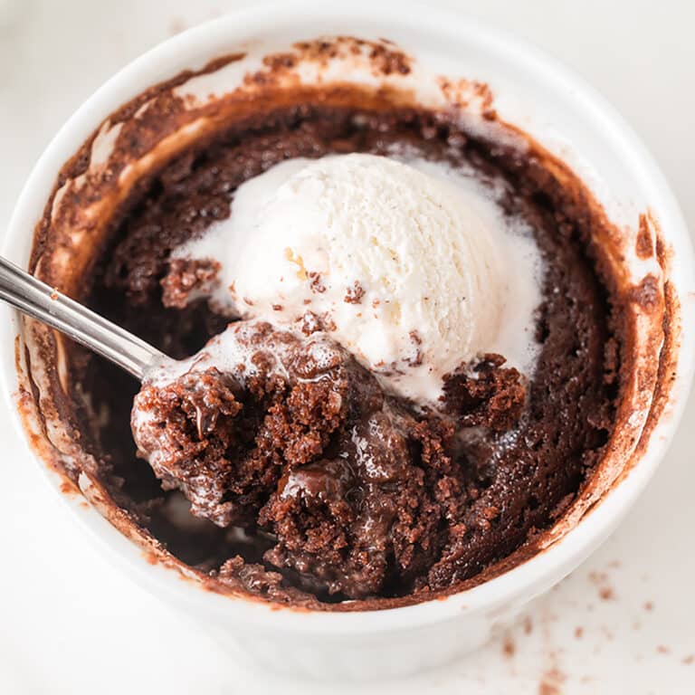 Warm single serve brownie topped with vanilla ice cream in a ramekin.