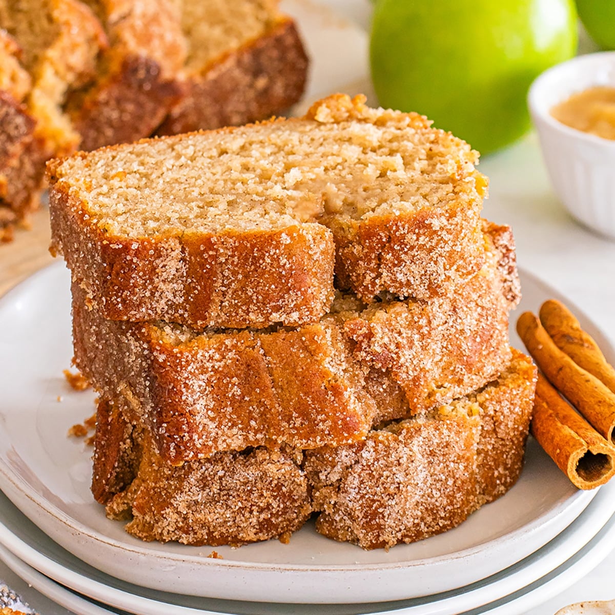 Stacked slices of cinnamon-sugar coated apple cider donut bread.